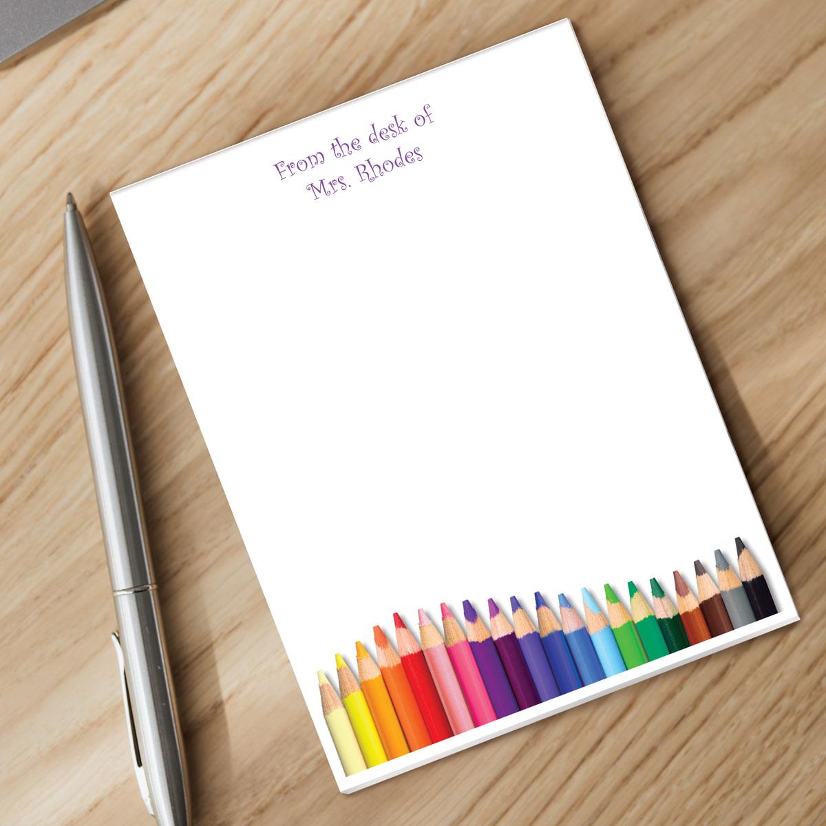 notepad with personalization and silver pen sitting on a desk