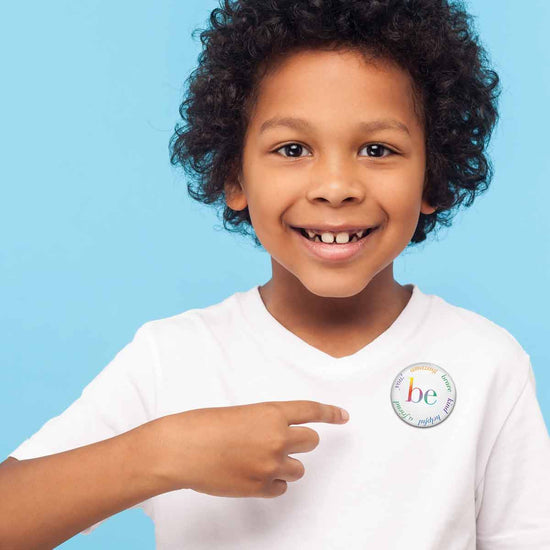 a child wearing a be collection button