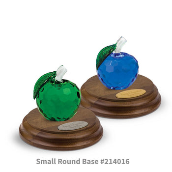 blue and green faceted crystal apples sitting on top of round walnut bases with brass and silver plates