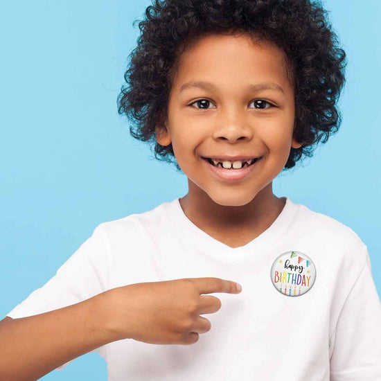 a child wearing a happy birthday button