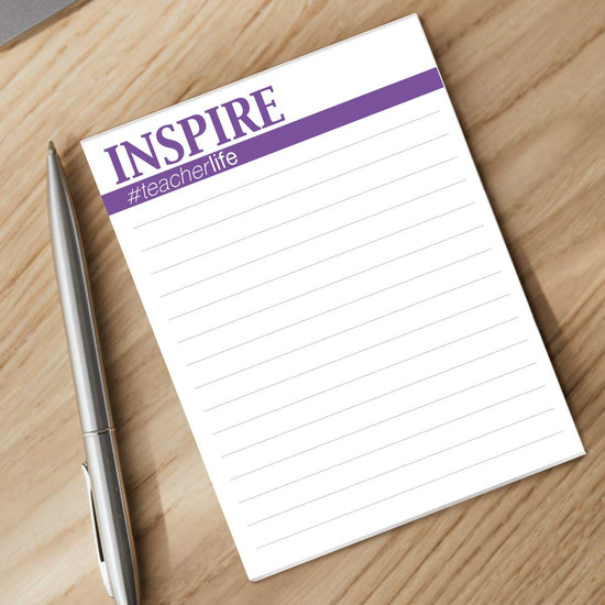 inspire notepad with a pen sitting on a desk