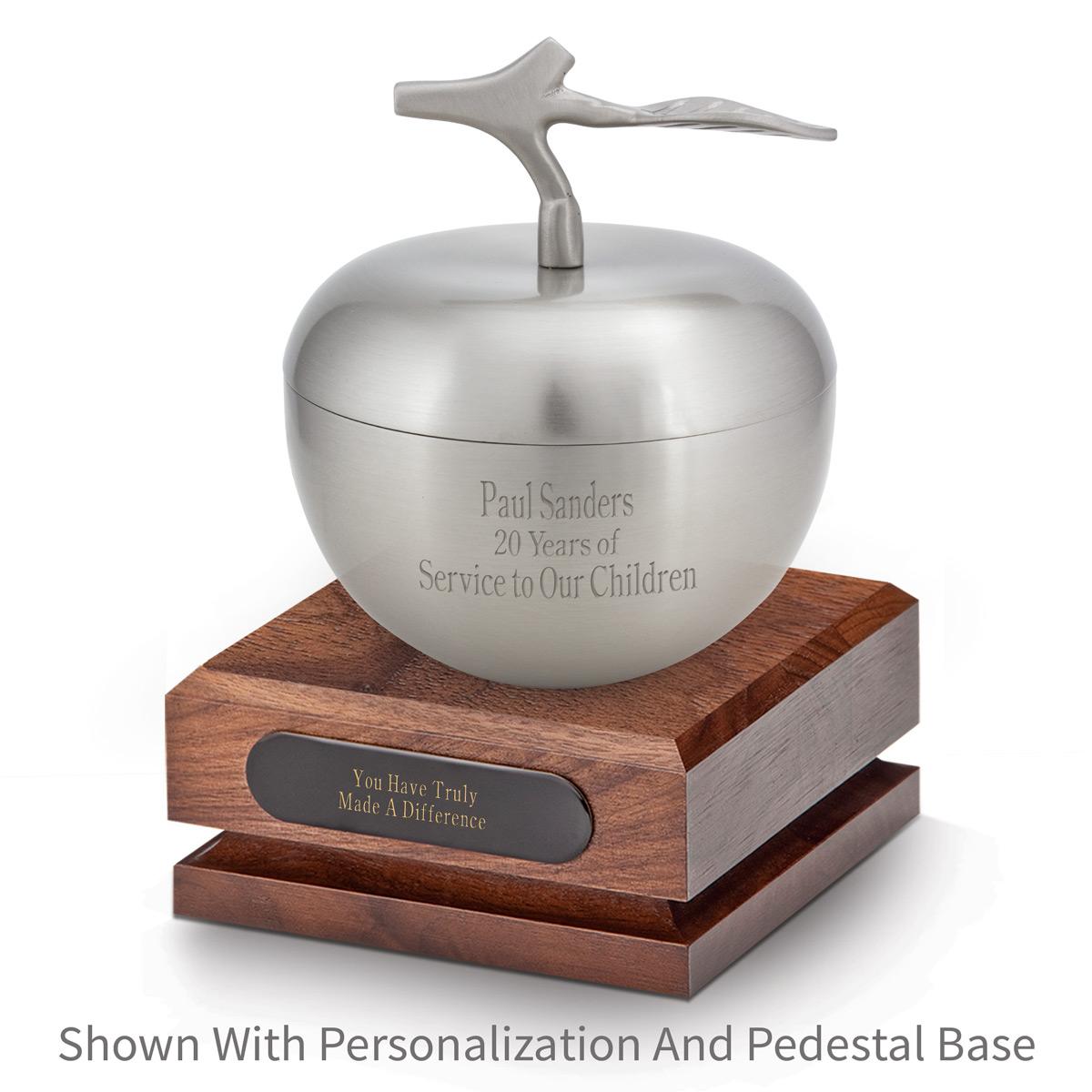 silver apple dish sitting on top a walnut base with black brass plate