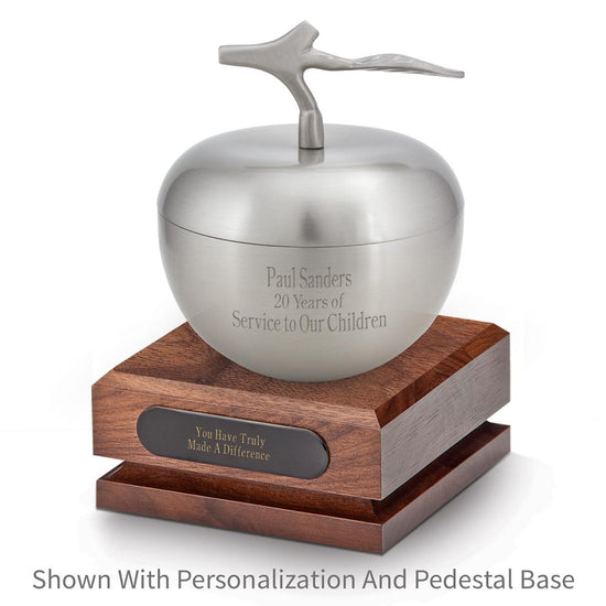 silver apple dish sitting on top a walnut base with black brass plate