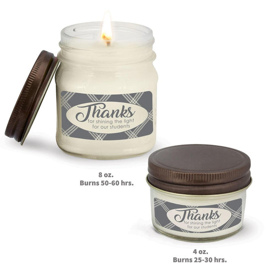 two white candle in glass jar with thanks for shining the light message