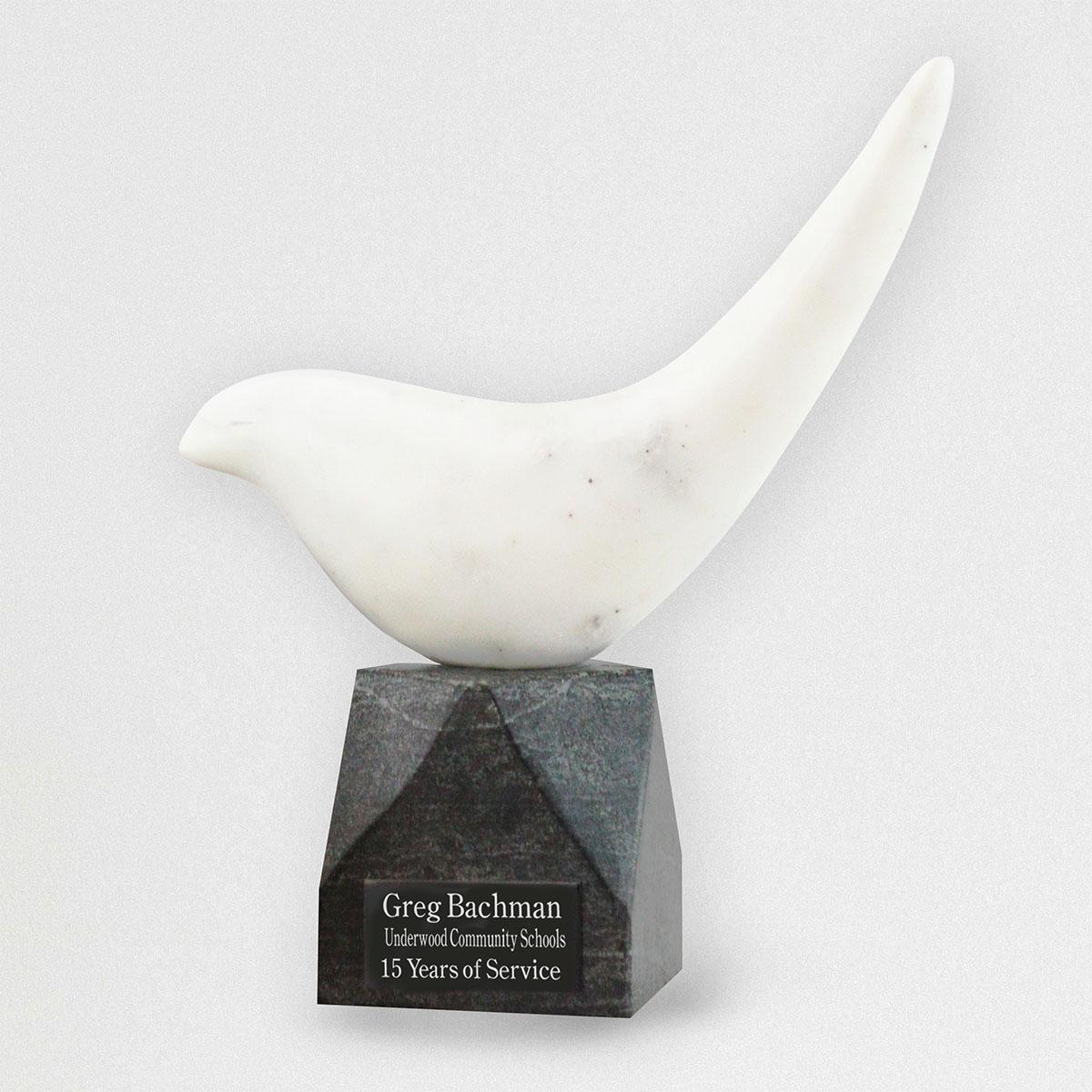 White marble modern bird statue on black marble base with plate for personalization.