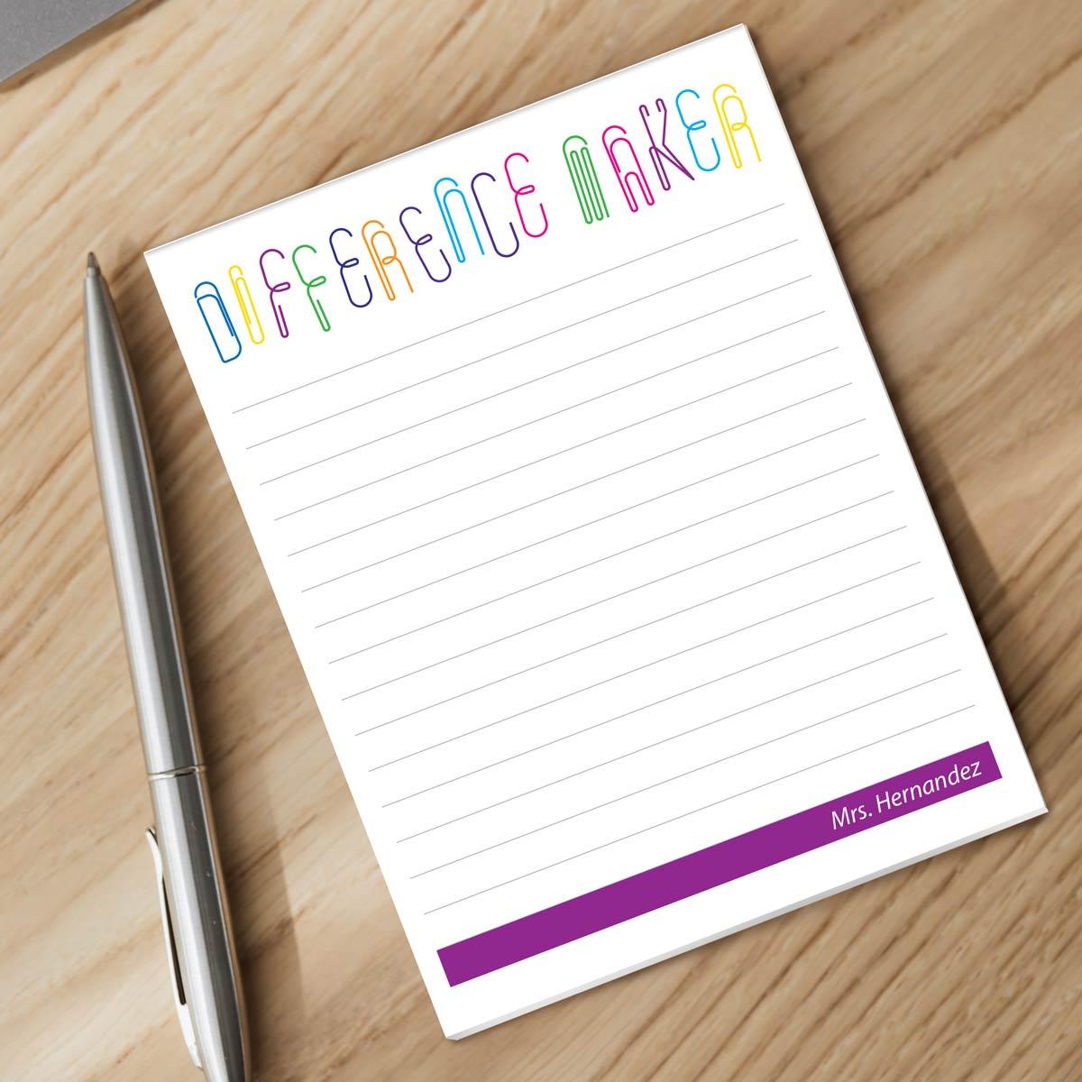 difference maker notepad and silver pen sitting on a desk