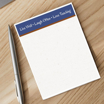 live laugh love notepad and silver pen sitting on a desk