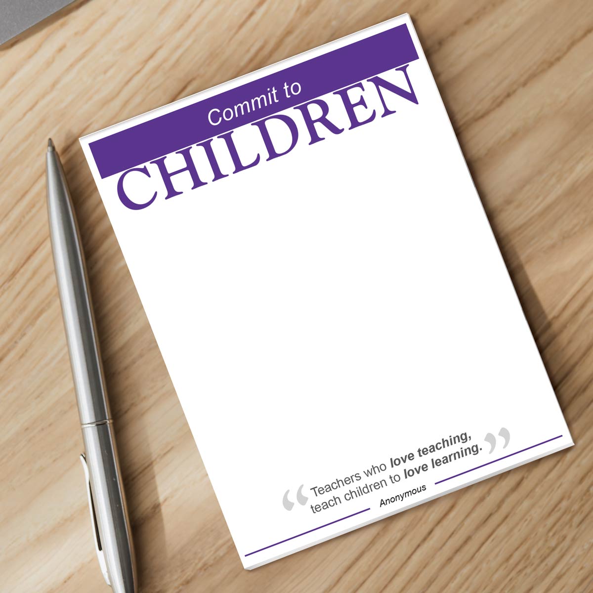 commit to children notepad and silver pen sitting on a desk