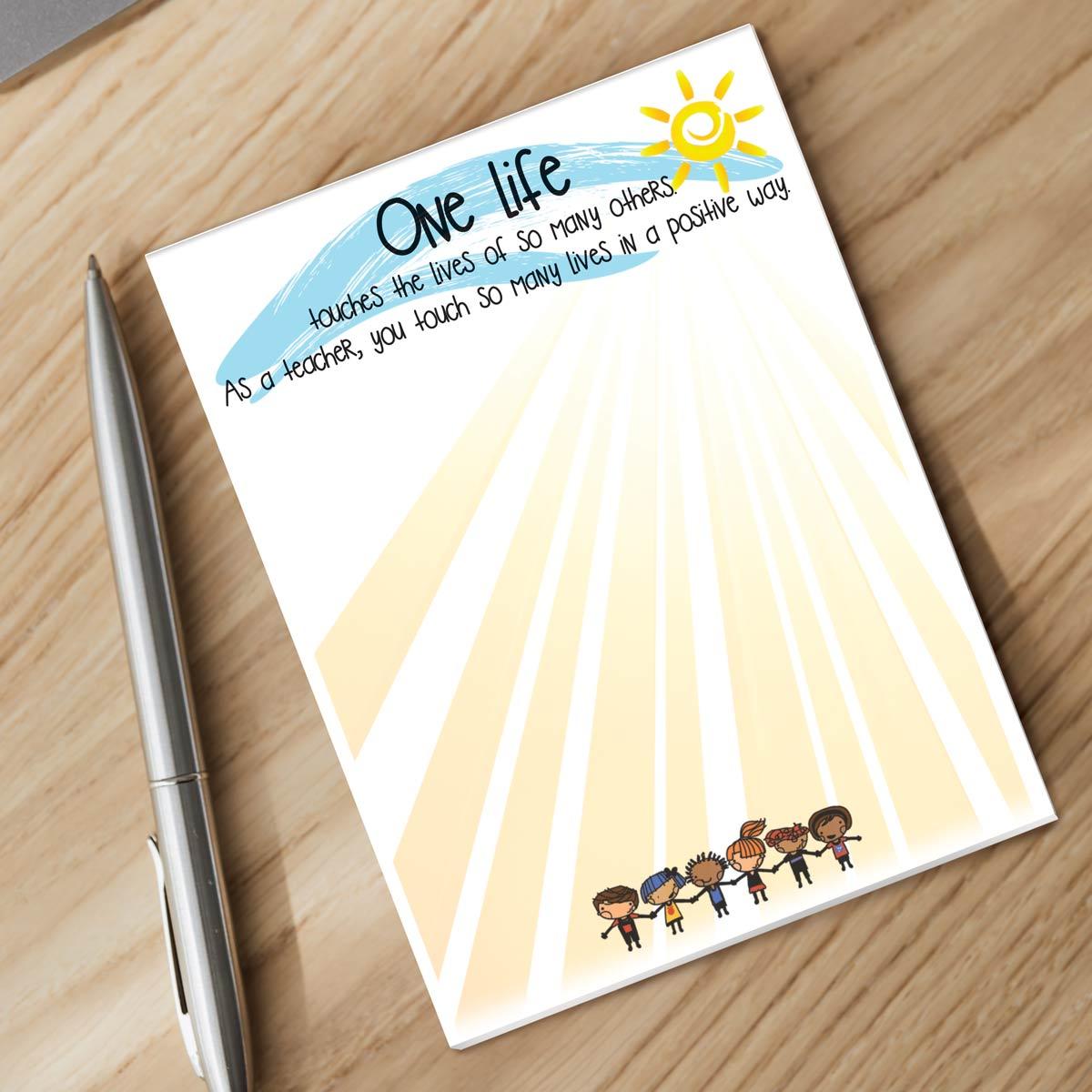 one life notepad and silver pen sitting on a desk