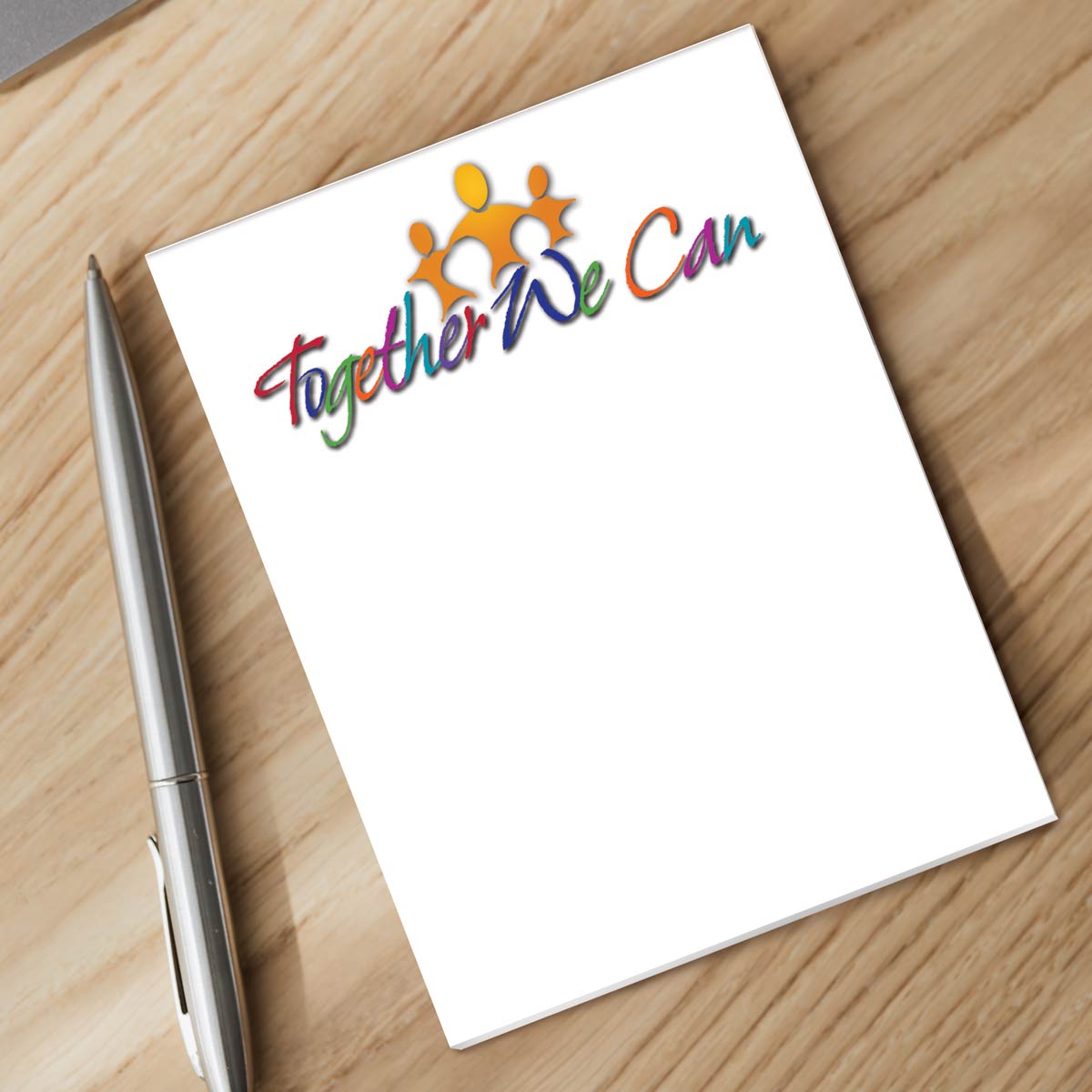 together we can notepad and silver pen sitting on a desk
