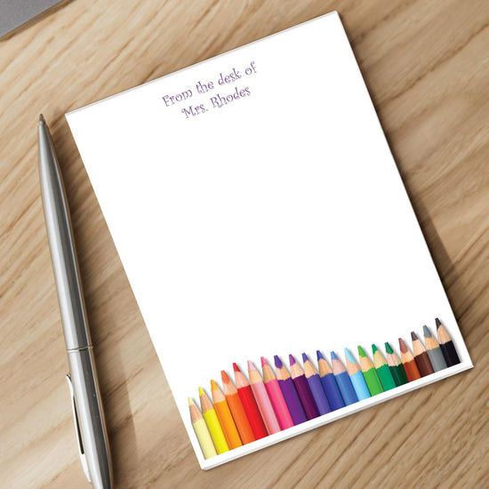 notepad with personalization and silver pen sitting on a desk