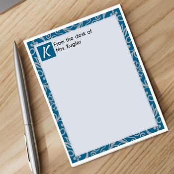 personalized notepad and silver pen sitting on a desk