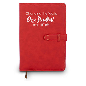 Hardbound journal with tab and loop closure. Cover reads: Changing The World One Student At A Time