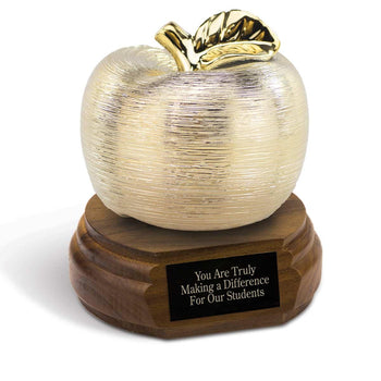 gold spun apple sitting on top a walnut base with black brass plate