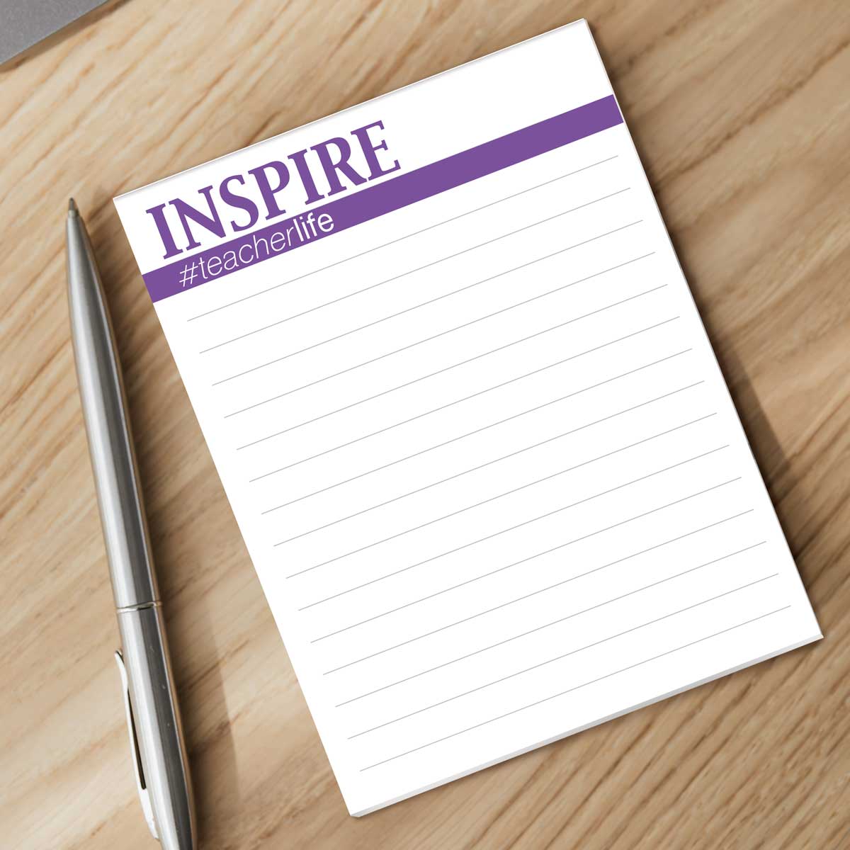 inspire notepad with a pen sitting on a desk