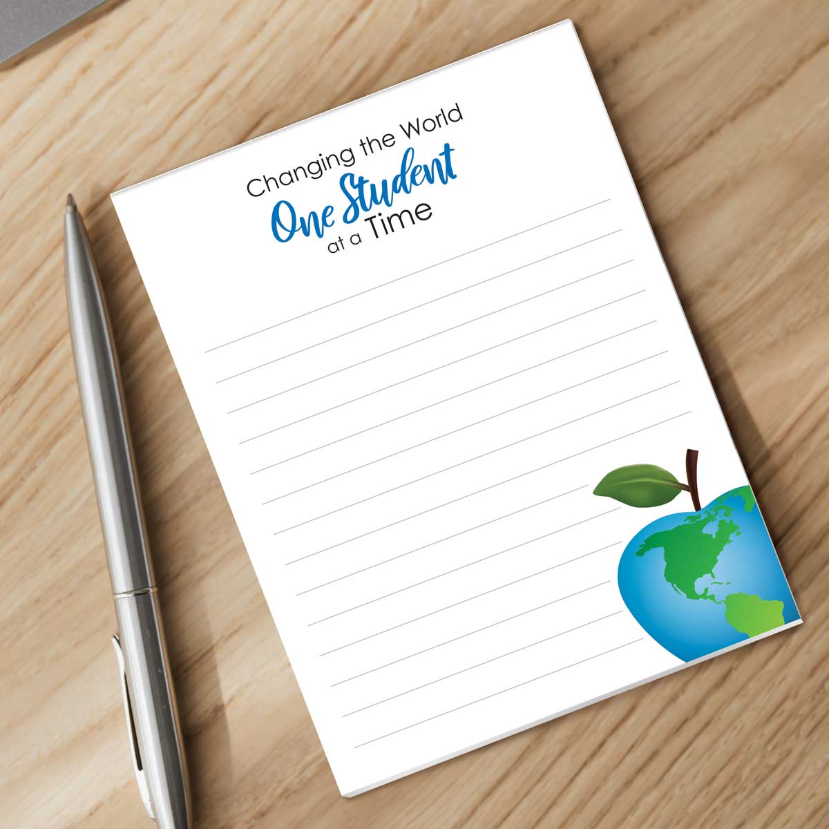 one student at a time notepad with a pen sitting on a desk