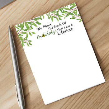 seeds of knowledge notepad with a pen sitting on a desk