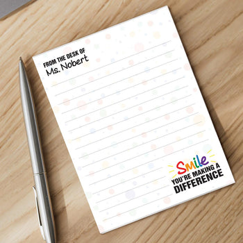 smile personalized notepad with a pen sitting on a desk