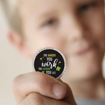a boy holding a harder you work coin