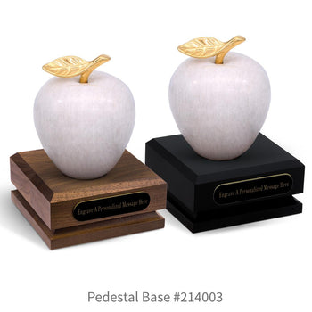 black and a brown walnut pedestal bases with black brass plates and white marble apples