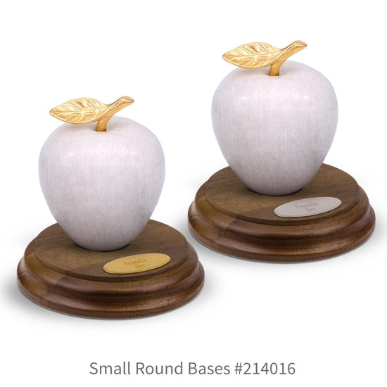 round walnut bases with brass and silver plates and white marble apples