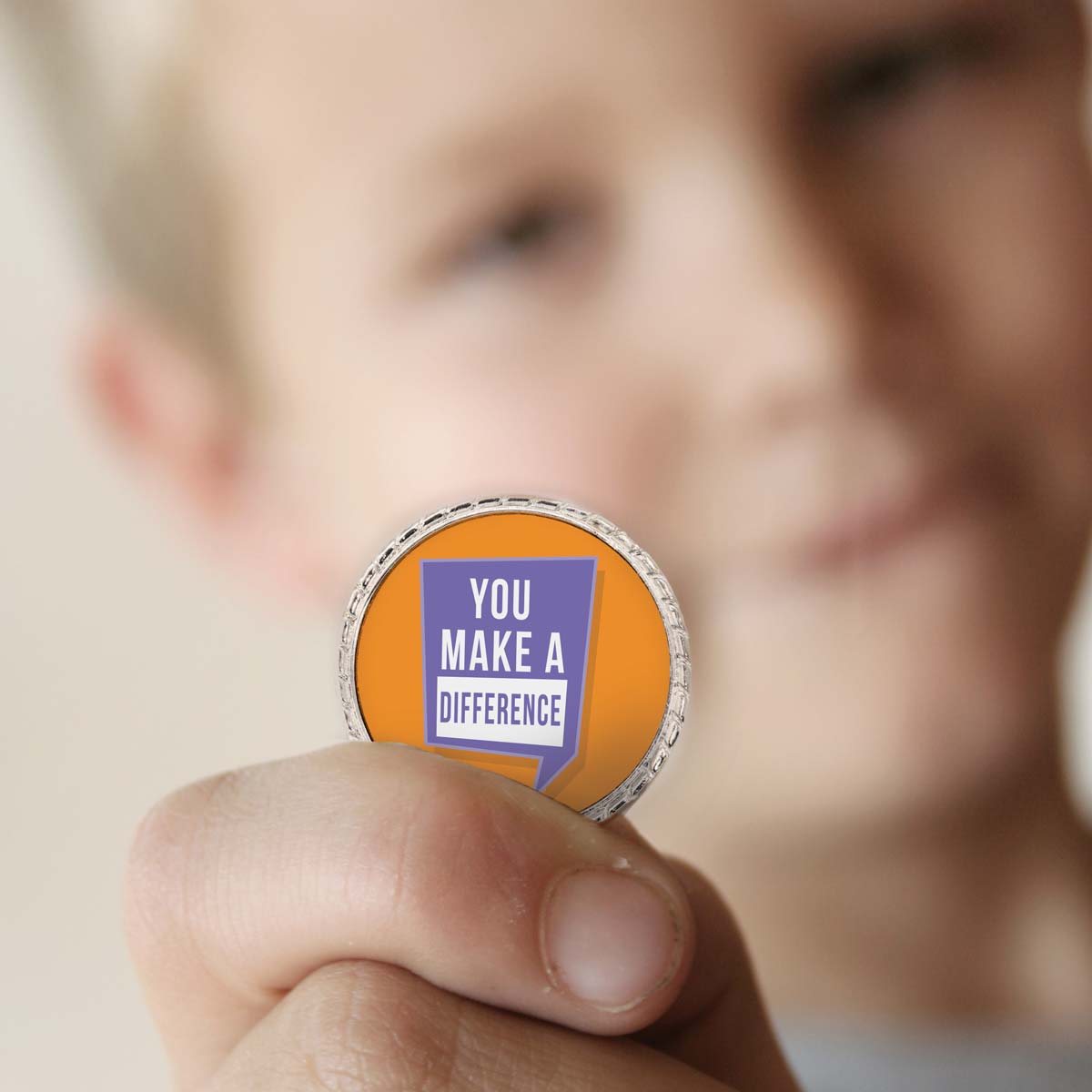 a boy holding a you make a difference coin