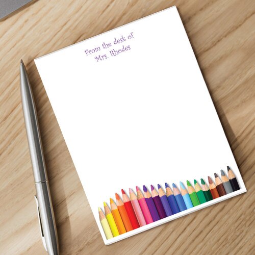 notepad with personalization and silver pen sitting on a desk