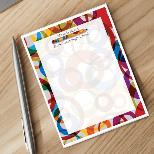 personalized notepad and silver pen sitting on a desk