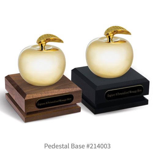 black and a brown walnut pedestal bases with black brass plates and brass apples