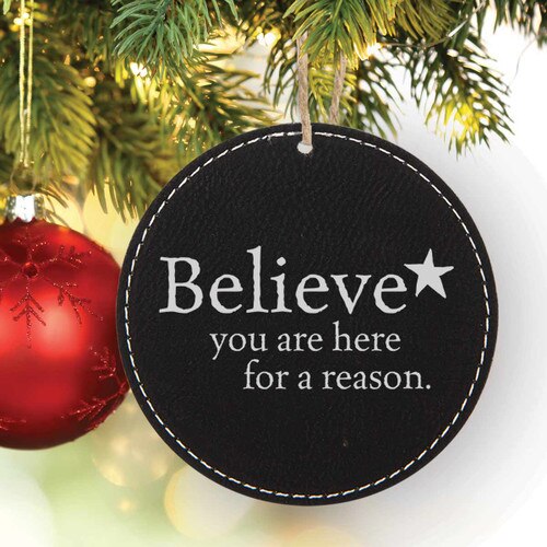a rustic round ornament with believe message