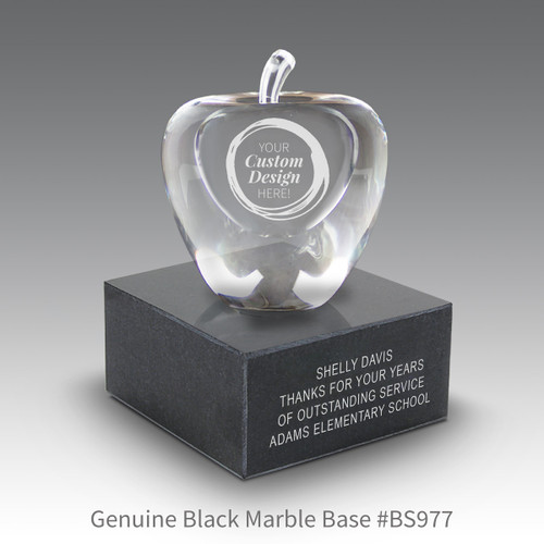 optic crystal apple sitting on top a black marble base