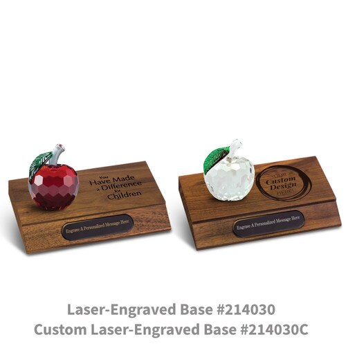 red and clear faceted crystal apples sitting on top of walnut laser engraved bases with black brass plates