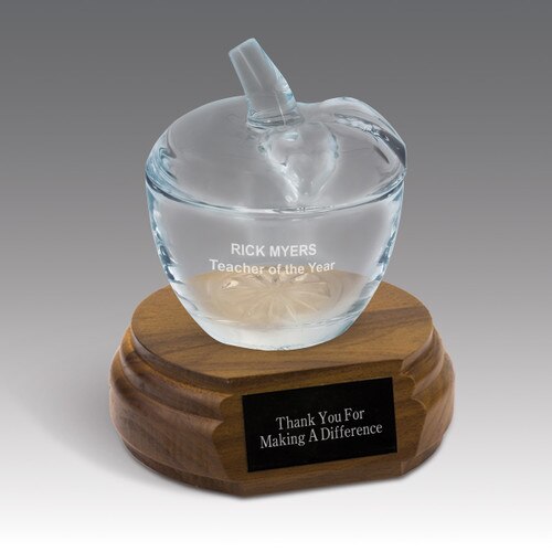 glass apple dish sitting on top a walnut base with black brass plate