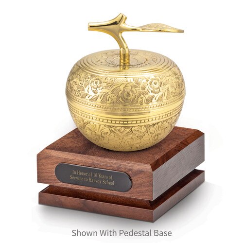 gold embossed apple dish sitting on top a walnut base with black brass plate
