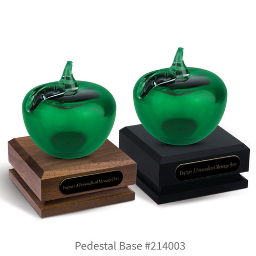 black and a brown walnut pedestal bases with black brass plates and green handblown glass apples