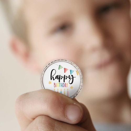 a boy holding a happy birthday coin