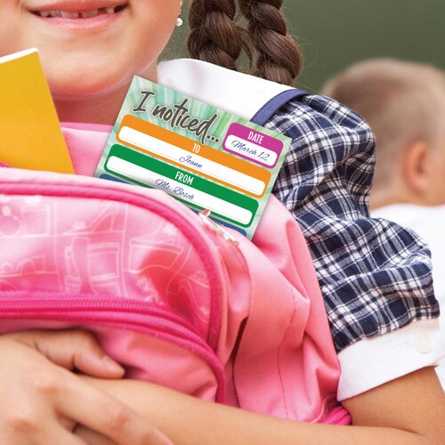 little girl holding a pink backpack with a Kudos notepad URL