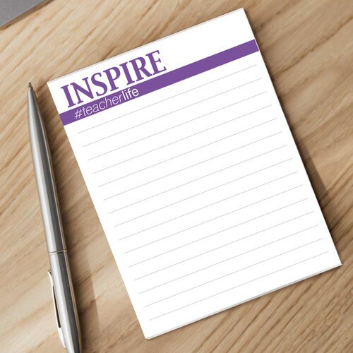 inspire notepad with a pen sitting on a desk