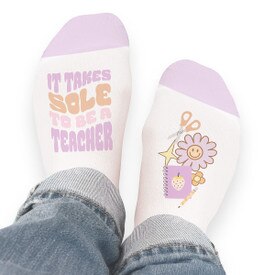 Pair of no-show socks with a black heel and a colorful It Takes Sole To Be A Teacher message on top.