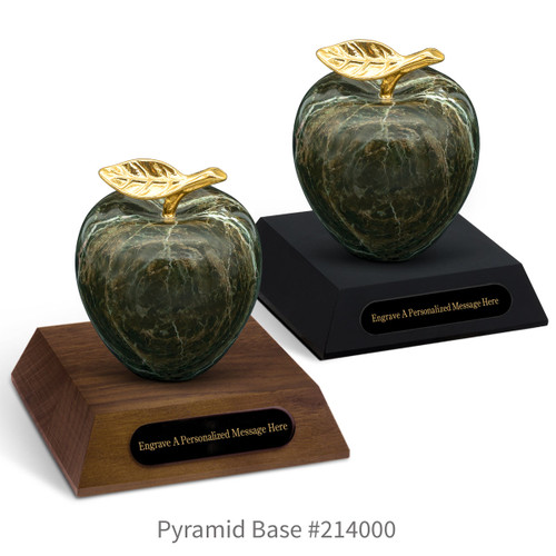black and a brown walnut pyramid bases with black brass plates and green marble apples