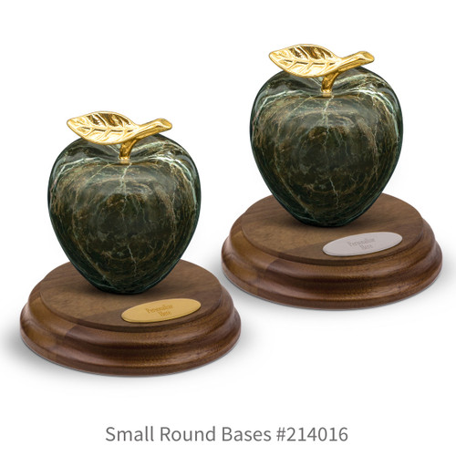 round walnut bases with brass and silver plates and green marble apples