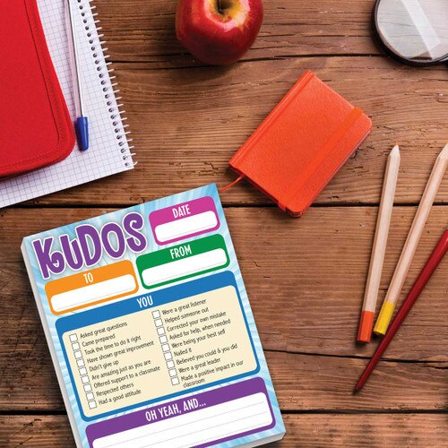 Kudos notepad with colored pencils, journal and apple