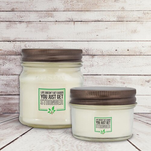 two white candle in glass jar with life doesn't get easier message