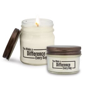 two white candle in glass jar with making a difference message