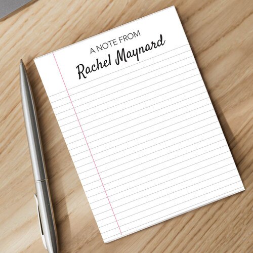 notepad with personalization and silver pen sitting on a desk
