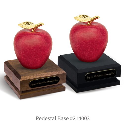 black and a brown walnut pedestal bases with black brass plates and marble apples