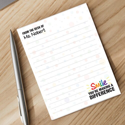 smile personalized notepad with a pen sitting on a desk