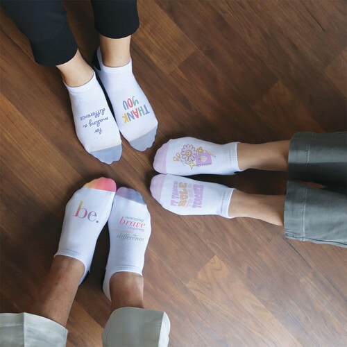 three people wearing no-show socks with messages printed on them