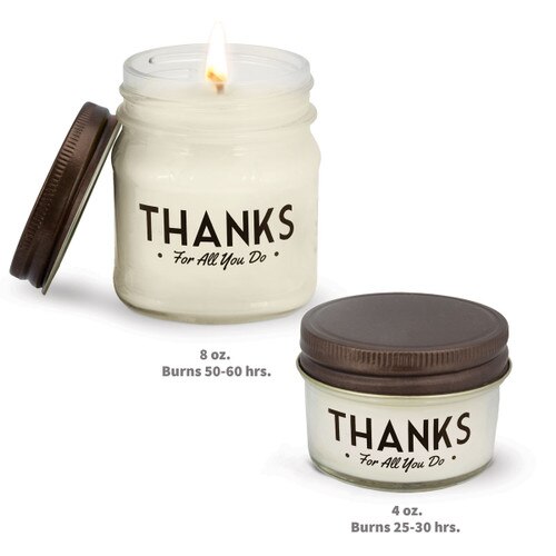 two white candles in glass jars with thanks message