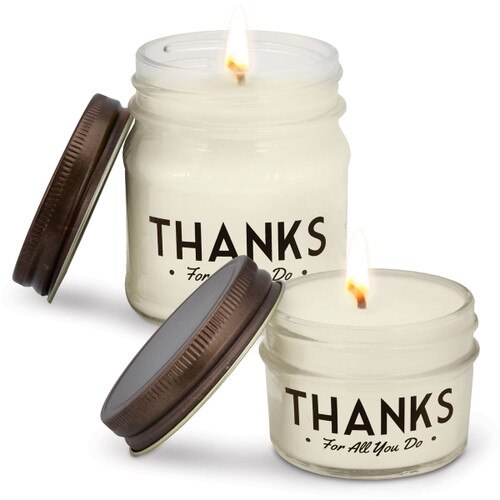 two white candles in glass jars with thanks message